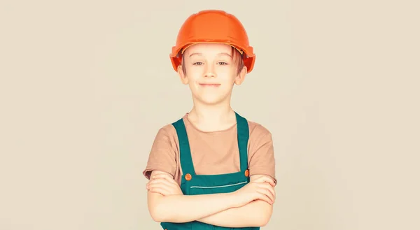 Un piccolo costruttore di cappelli duri. Casco da bambino, cappello rigido. Un piccolo costruttore in casco. Bambino vestito da operaio. Ragazzino con il casco — Foto Stock