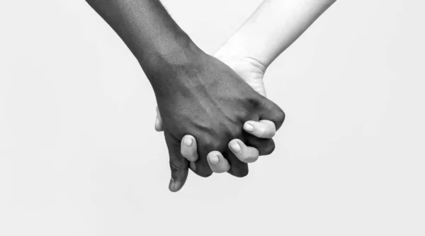 In bianco e nero Love Partnership mano. Donna nera, bianca e uomo che tengono le mani unite. Donna Bianca, uomo africano che tiene per mano il simbolo dell'amicizia. Simbolo della pace africana. Coppie di razza mista che si tengono per mano — Foto Stock