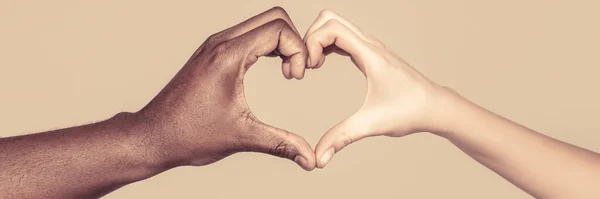 Las personas de diferentes colores de piel ponen sus manos juntas haciendo que la forma del corazón en fondo blanco. Caridad, amor y diversidad - primer plano de las manos femeninas y masculinas de diferente color de piel haciendo — Foto de Stock