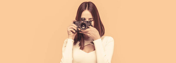 Woman holding camera over yellow background. Girl using a camera photo. Photographer camera photo, photographing girl joy make photography taking concept. Girl with a cameras