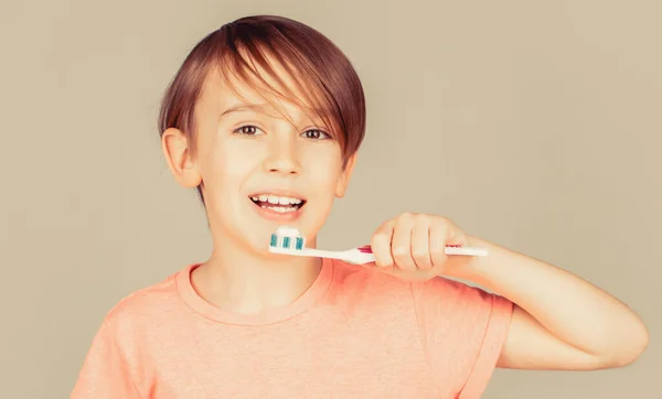 Radosne dziecko pokazuje szczoteczki do zębów. Mały chłopiec czyści zęby. Higiena jamy ustnej. Szczęśliwy dzieciak myjący zęby. Chłopiec myjący zęby. Chłopiec szczoteczka biała pasta do zębów. Opieka zdrowotna, higiena zębów — Zdjęcie stockowe