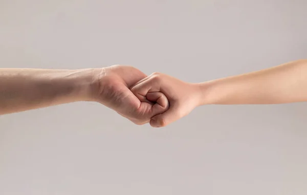 Женские и детские руки связаны друг с другом. Дружеское рукопожатие, приветствие друзей. Спасение, рука помощи. Человек помогает руками, защищает. Мужские и детские руки соединили друг друга и навсегда — стоковое фото