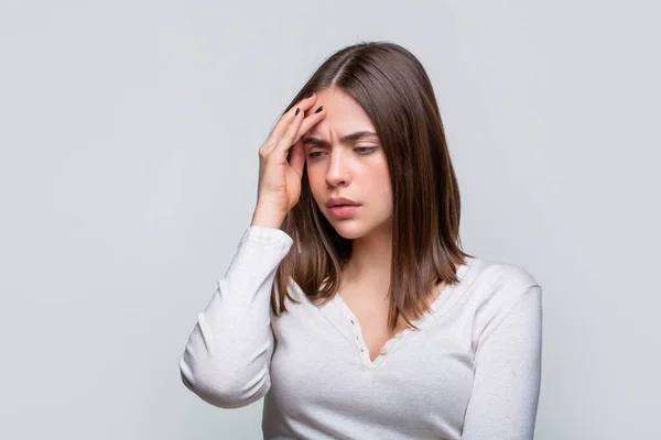 Donna che soffre di mal di testa disperata, stressata perché il dolore e l'emicrania. Donna con forte mal di testa che si tiene per mano. Donna bruna toccare le tempie sensazione di stress, su sfondo grigio — Foto Stock