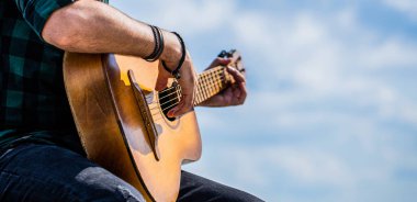 Akustik gitarlar çalıyor. Müzik konsepti. Gitar akustiği. Gitar çalan erkek müzisyen, müzik aleti. Akustik gitar çalan erkek elleri, yakın çekim.