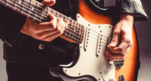 Musical instrument. Electric guitar. Repetition of rock music band. Music festival. Man playing guitar. Close up hand playing guitar. Musician playing guitar, live music
