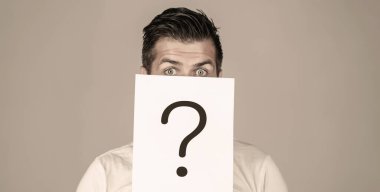 Bir sorum var. Soru işareti tutan şüpheli bir adam. Sorunlar ve çözümler. Cevapları alıyorum. İnsan portresi, sorgulama sembolünün arkasına bakıyor. Erkek izole edilmiş.