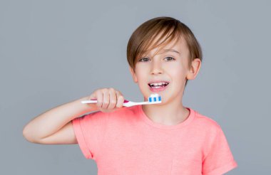 Erkek diş fırçası beyaz diş macunu. Sağlık hizmeti, diş hijyeni. Neşeli çocuk diş fırçalarını gösteriyor. Diş temizleyen küçük çocuk. Diş hijyeni. Küçük mutlu çocuk dişlerini fırçalıyor. Çocuk dişlerini fırçalıyor.
