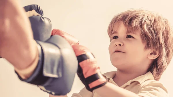 Father is training his son boxing. Little boy doing boxings exercise with grandfather. Little boy sportsman at boxing training with coach. Sports man coaching boxing little boy in red boxing gloves — Stock Photo, Image