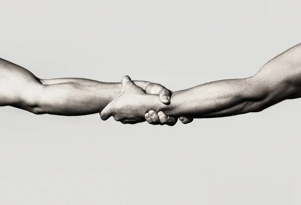 A friendly handshake. Two hands, shaking hands. Two hands, helping arm of a friend, teamwork. Rescue, helping gesture or hands. Close up help hand. Helping hand concept, support — Stock Photo, Image