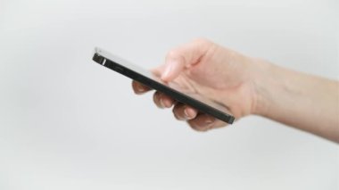 Akıllı cep telefonu kullanarak yakın çekim yapan adam. El ele tutuşan akıllı telefon cihazı ve dokunaklı ekran. El ekranı tutuyor, cep telefonu beyaz arka planda izole edilmiş.