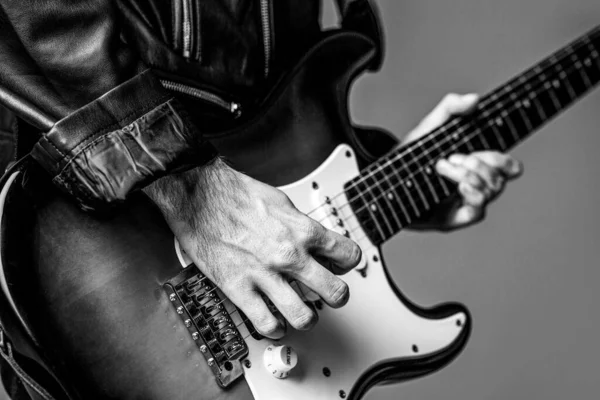 Man playing guitar. Close up hand playing guitar. Musician playing guitar, live music. Electric guitar. Repetition of rock music band. Music festival