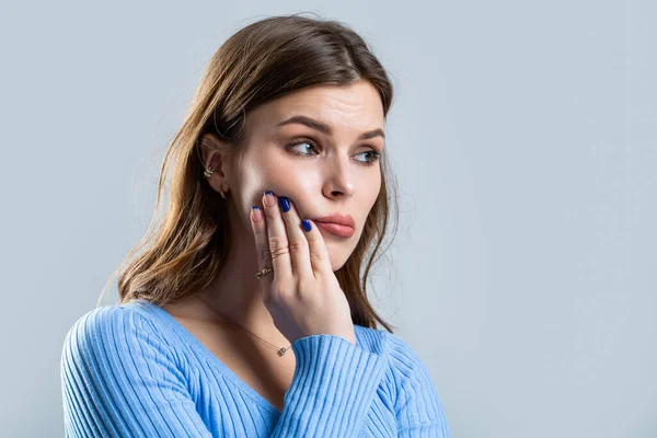 歯の感染症の女性 灰色の背景に歯痛を患っている女性 歯痛を患っている若い女性 感度に苦しむ少女 — ストック写真