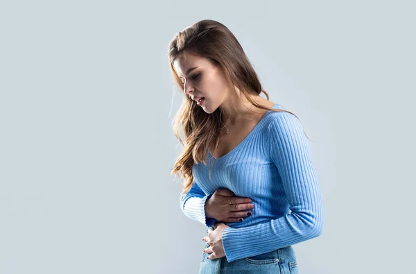 Woman touching his stomach. Stomach pain and others stomach disease concept.Girl having a stomachache. Young woman suffering from abdominal pain. Woman Stomach Ache.