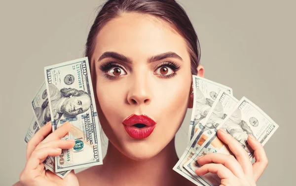 Girl holding cash money in dollar banknotes. Woman holding lots of money in dollar currency. Luxury, beauty and money concept.