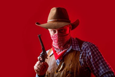 Kovboy portresi. Amerikalı çiftçi. Kovboy şapkalı, silahlı, maço bir adamın portresi. Batı, silahlar. Maskeli Amerikalı haydut, şapkalı batılı adam. Şapkalı bir kovboy ya da çiftçi portresi.