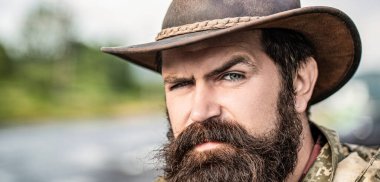 Deri Kovboy Şapkası. Kovboy şapkası takan genç bir adamın portresi. Şapkalı kovboylar. Yakışıklı sakallı maço. Tıraşsız kovboylar. Amerikan kovboyu.