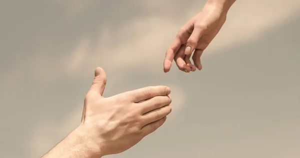 Lending a helping hand. Solidarity, compassion, and charity, rescue. Hands of man and woman reaching to each other, support.