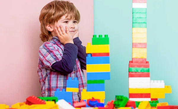 Child playing with colorful toy blocks. Educational toys for young children. Little boy playing with lots of colorful plastic blocks constructor.