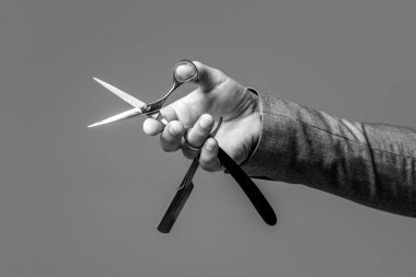 Vintage barber shop, shaving. Vintage barbershop. Barber scissors and straight razor, barber shop, suit. Brutal guy, scissors, straight razor. Client visiting barber shop. Black and white.