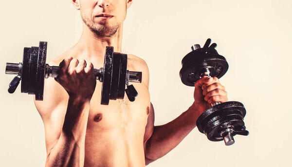 Weak man lift a weight, dumbbells, biceps, muscle, fitness. Nerd maleraising a dumbbell.