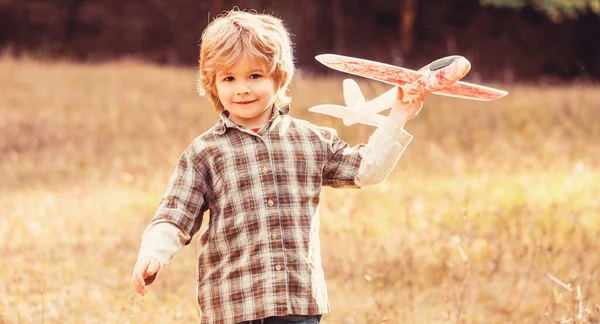 快乐的男孩玩飞机 带着飞机的小男孩小孩梦想成为一名飞行员 — 图库照片
