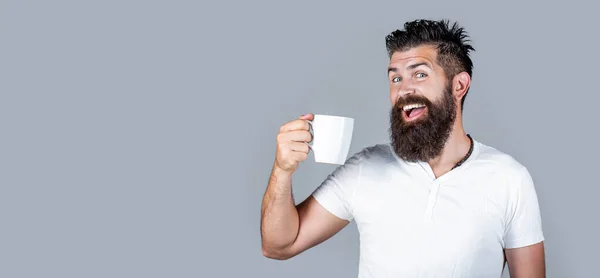 Bearded man smiling. Good morning, man tea. Smiling hipster man with cup of fresh coffee, Happy man. Morning concept. Handsome man holds cup of coffee, tea.