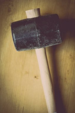 Ahşap bir arka planda büyük bir lastik çekiç yakın çekim.