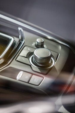 Araba panelinde düğmeleri olan modern merkezi konsolun yakın çekim görüntüsü.