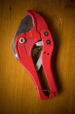 Ahşap bir arka planda bir PVC boru kesici aracının yakın çekim görüntüsü.