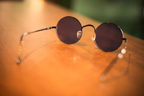Ett Par Svarta Rundade Solglasögon Träyta — Stockfoto