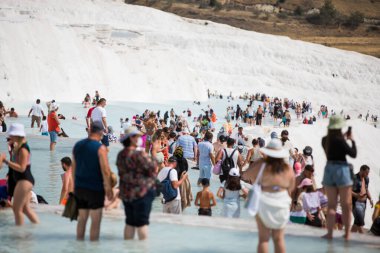 Pamukkale, TURKEY - 24 Temmuz 2021: Pamukkale, Türkiye 'deki travertin teraslarının ve oradan geçen turistlerin görüntüleri.