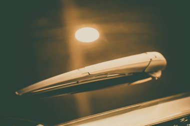 Bir arabanın ön camında modern bir arka ekran sileceğinin yakın çekim görüntüsü.