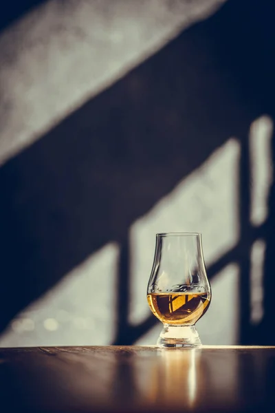 背景に光と影のあるグレンセアンシングルモルトウイスキーグラスのイメージ — ストック写真
