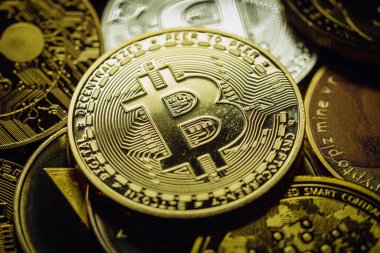 Diğer dijital kripto para birimlerinin yanı sıra, bir yığın içinde altın bir Bitcoin 'in yakın plan çekimi .
