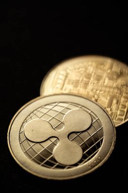 Altın dalgalı XRP dijital kripto para biriminin yakın çekim görüntüsü, ön ve arka.