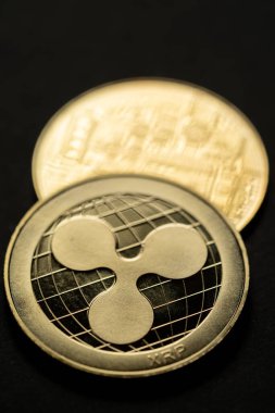 Altın dalgalı XRP dijital kripto para biriminin yakın çekim görüntüsü, ön ve arka.