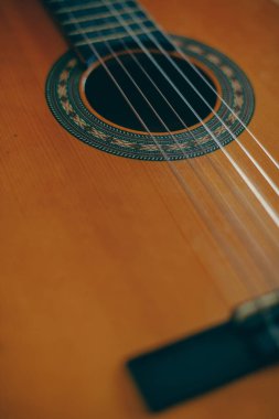 Plastik telli, ahşap bir klasik gitarın yakın plan çekimi..