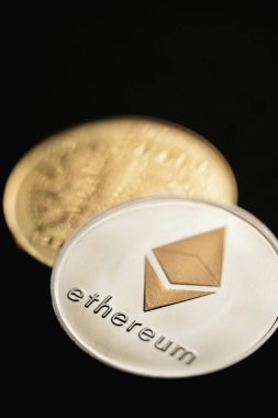 Gümüş bir Ethereum dijital kripto para biriminin yakın plan çekimleri, ön ve arka.