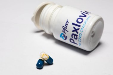 Bükreş, Romanya - 1 Şubat 2022: Pfizer tarafından geliştirilen oral antiviral ilaç hapı Paxlovid 'in illüstrasyon konsepti. Corona virüsü Covid-19 tedavisi.