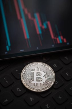 Altın Bitcoin kripto para mum çubuğu grafik şeması, dizüstü bilgisayar klavyesi ve dijital arkaplan.