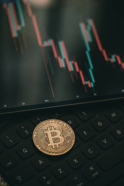 Altın Bitcoin kripto para mum çubuğu grafik şeması, dizüstü bilgisayar klavyesi ve dijital arkaplan.