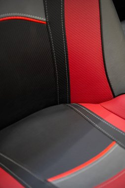 Siyah ve kırmızı deri kaplamalı modern spor araba. Beyaz dikişli deri araba koltuğu detayları..