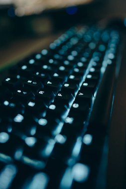 Düşük ışıkta bir klavyenin koyu görüntüsünü kapat.