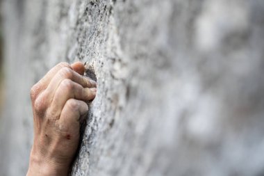 Yetişkin bir erkeğin bir kayaya tutunduğu yakın çekim, kaya tırmanışı için çizimler..