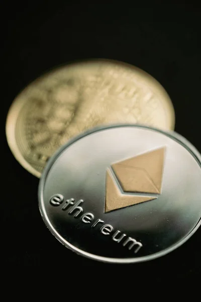 Close up shot of a silver Ethereum digital cryptocurrency coin, front and back.