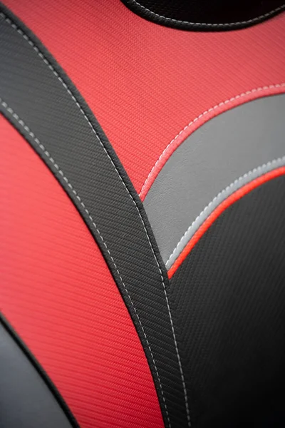Siyah ve kırmızı deri kaplamalı modern spor araba. Beyaz dikişli deri araba koltuğu detayları..