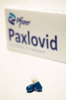 Bükreş, Romanya - 1 Şubat 2022: Pfizer tarafından geliştirilen oral antiviral ilaç hapı Paxlovid 'in illüstrasyon konsepti. Corona virüsü Covid-19 tedavisi.
