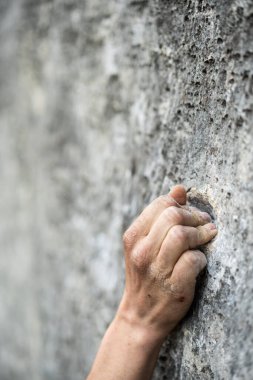 Yetişkin bir erkeğin bir kayaya tutunduğu yakın çekim, kaya tırmanışı için çizimler..