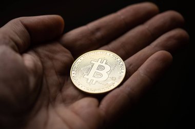 Gümüş bir bitcoin dijital kripto para tutarken yakın çekim.