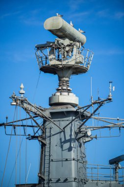 Image of  a military radar air surveillance on navy ship tower.